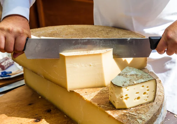 Man cutting piece of cheese — Stock Photo, Image