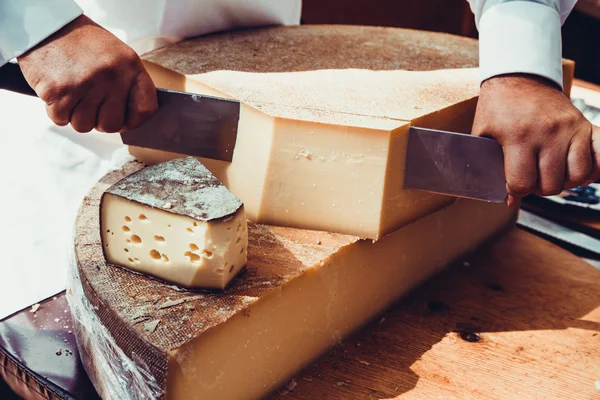 Lavoratore affettare il formaggio. Primo piano del taglio del formaggio. — Foto Stock