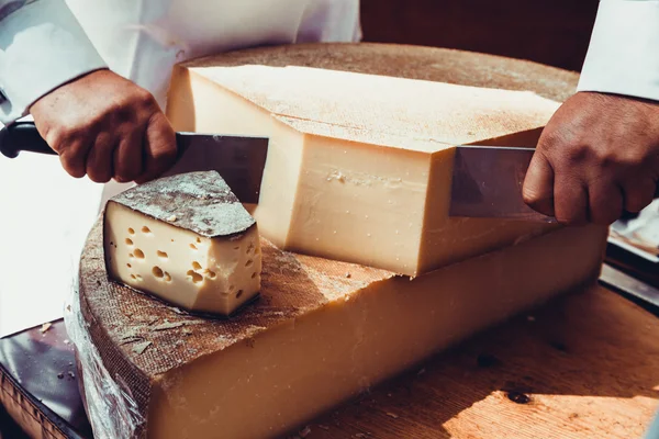 Worker slicing the cheese — Stock Photo, Image