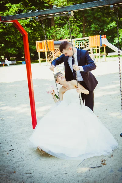 Casamento casal se divertindo no balanço — Fotografia de Stock