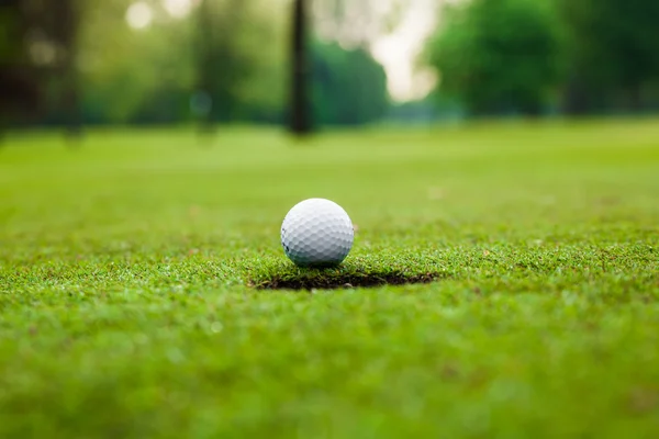 Pelota de golf en el labio de la taza — Foto de Stock