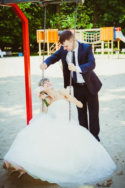 Wedding couple having fun on swing — Stock Photo, Image