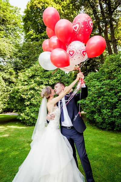 Пара позирующих с воздушными шарами — стоковое фото