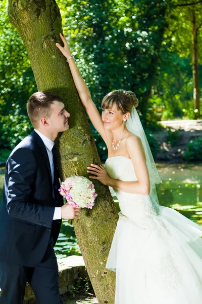 Mariée et marié posant dans un parc — Photo