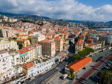 Sanremo şehir panoramasının yüksek açılı insansız hava aracı görüntüsü. Imperia eyaletinde tarihi İtalyan binalarının, renkli cephelerin ve bulutlu bir gökyüzünün altındaki sokakların manzarası.
