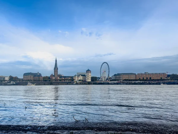 Düsseldorf şehrinin geniş bir manzarası vardır. Ren Nehri, St. Lambertus Kilisesi ve Almanya 'daki setin üzerindeki dönme dolap yer almaktadır.