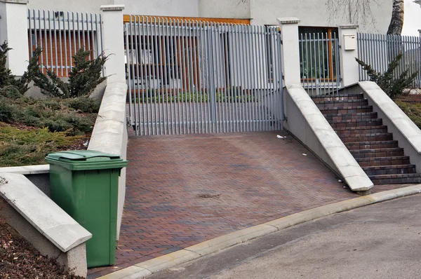 Iron gate and green trash — Stock Photo, Image