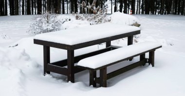 Ormandaki masa ve piknik tezgahı karla kaplı.