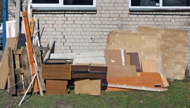 Apartmanın yakınındaki çöplükte eski kırık mobilyalar.