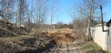 Köy yolunda büyük toprak ve kum yığınları var. Panoramik manzara