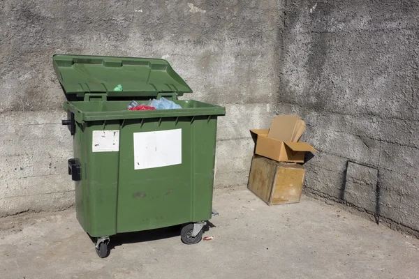 Green garbage container in concrete well — Stock Photo, Image