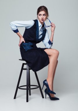 Gözlük tutan office sandalyede oturan işkadını