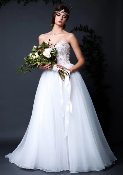 Žena mladá nevěsta ve svatebních šatech na šedém pozadí — Stock fotografie