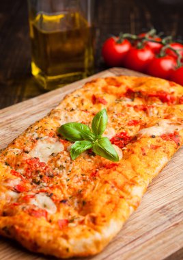 Pizza ekmek domates ve zeytinyağı ahşap tahta üzerinde