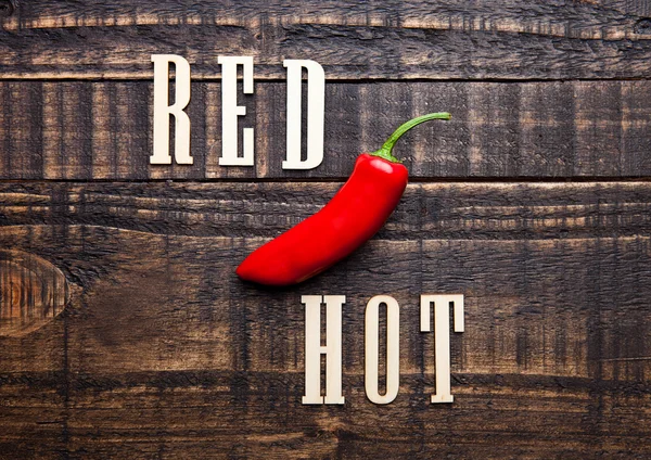 Röd het mexikansk peppar på träskiva med bokstäver — Stockfoto