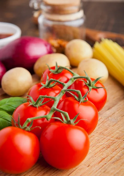 Fresh tomatoes with vegetables on wooden board — Stock Photo, Image