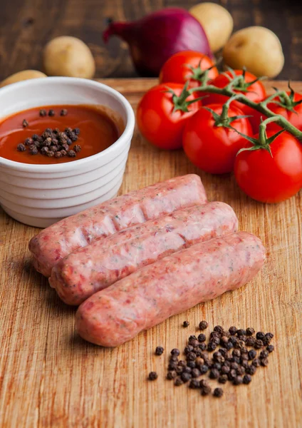 Salsichas de carne crua com tomate e sause a bordo — Fotografia de Stock