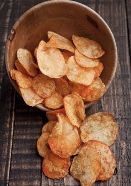 Ahşap tahta üzerindeki fişlere kase patates cips