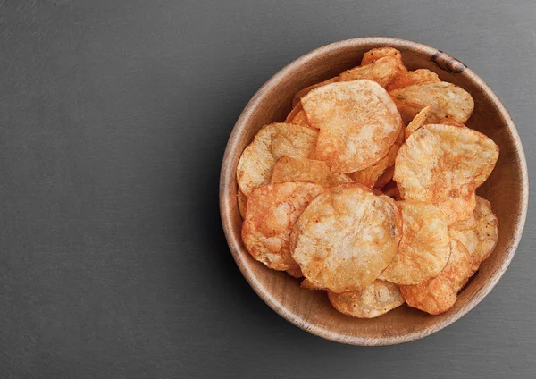 Bowl with potato crisps chips on black stone board — Stock Photo, Image