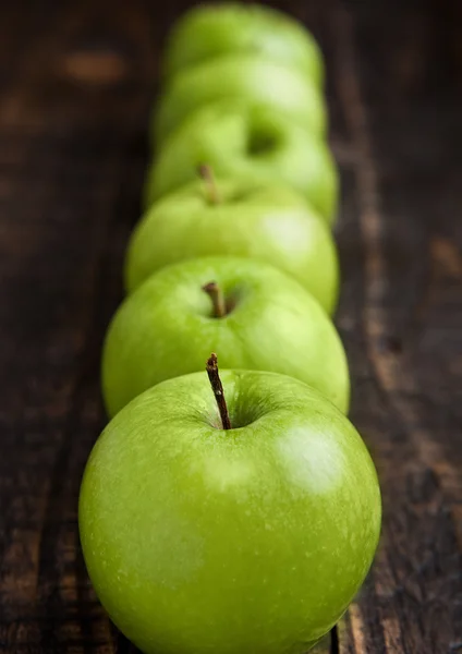 Green organic healthy apples on wooden board — Stock Photo, Image