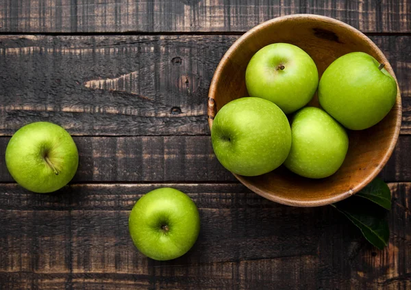 Green organic healthy apples in bowl on wooden board — Stock Photo, Image
