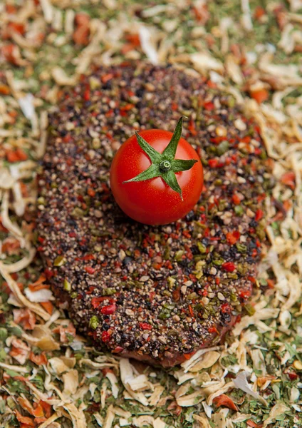 Говядина сырой стейк с помидорами на специях — стоковое фото