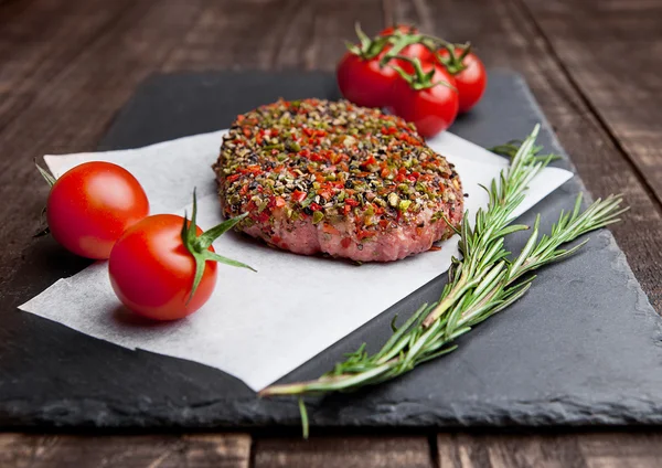 Hovězí tatarský biftek s paprikou a rajčaty na kamenné desce — Stock fotografie