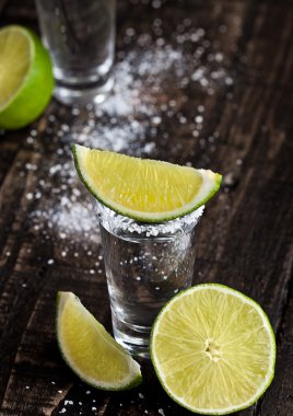 Tequila Gümüş kireç dilimleri ile vurdu ve ahşap tahta üzerinde tuz