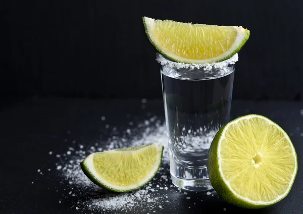 Tequila colpo d'argento con fette di lime e sale su tavola di pietra — Foto Stock