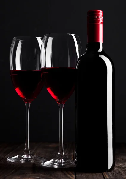 Red wine bottle and glasses on wooden table black — Stock Photo, Image