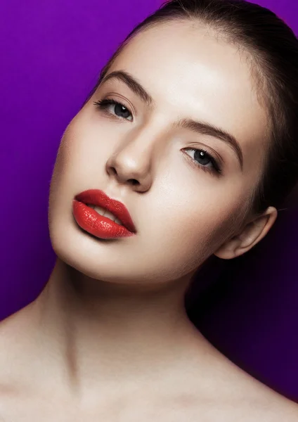 Belle femme avec des lèvres rouges maquillage sur fond violet — Photo