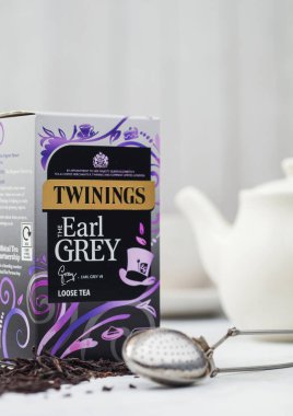 LONDON, İngiltere - 21 Ekim 2020: Twinings Earl Grey seramik çaydanlık ve beyaz arka planda süzgeç infüzyoncusu ile gevşek çay.