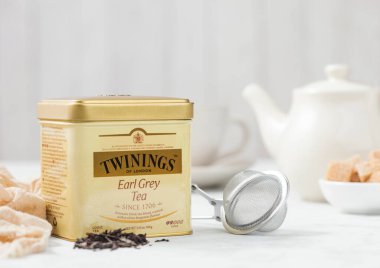 LONDON, İngiltere - 21 Ekim 2020: Çelik kavanoz Twinings Earl Grey gevşek çay ile demir çaydanlık ve süzgeç aşılayıcı beyaz arka planda. Cam bardakla.