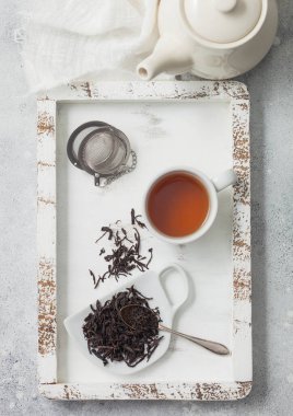 Çay topu süzgeci katkılı siyah çay ve beyaz keten bezli tahta kutuda fincanlı seramik çaydanlık. Üst görünüm