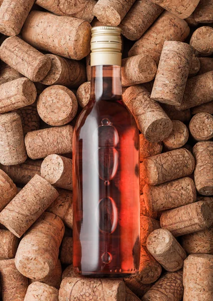 Arka Planda Şarap Mantarlarının Üzerine Bir Şişe Pembe Gül Şarabı — Stok fotoğraf