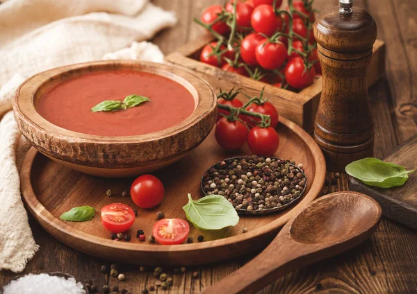 木版奶油番茄汤圆盘子 胡椒粉和厨房用布和一盒生西红柿放在木板上 — 图库照片