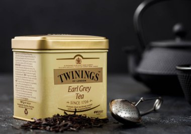 LONDON, İngiltere - 21 Ekim 2020: Çelik Twinings kavanozu, çaydanlıklı gevşek çay ve siyah arka planda süzgeç infüzörü.