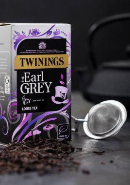 LONDON, İngiltere - 21 Ekim 2020: Bir kutu Twinings Earl Grey gevşek çay ve siyah arka planda süzgeç infüzörü.
