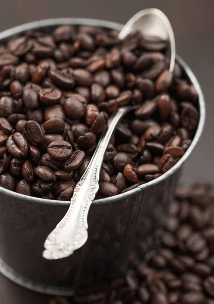 Fresh Raw Coffee Beans Steel Bucket Container Spoon Brown Background — Φωτογραφία Αρχείου