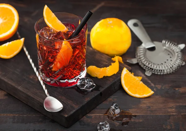 Negroni Koktél Kristályüvegben Narancsszelettel Friss Nyers Naranccsal Szűrővel Kanállal Sötét — Stock Fotó