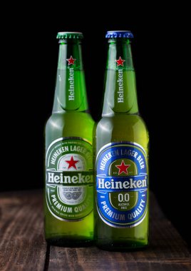LONDON, UK - 27 Nisan 2018: Koyu ahşap arka planda Heineken şişeleri ve alkolsüz bira. Heineken, Heineken Enternasyonal 'ın sancak gemisi.