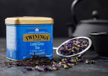 LONDON, İngiltere - 21 Ekim 2020: Çelik kavanoz Twinings Lady Grey demir çaydanlık ve siyah zemin üzerinde mavi mallow çiçekleri ile gevşek çay.