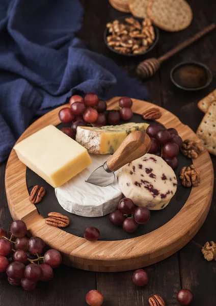 Tahtada Çeşitli Peynirler Ahşap Masa Arkasında Üzümler Mavi Stilton Kırmızı — Stok fotoğraf