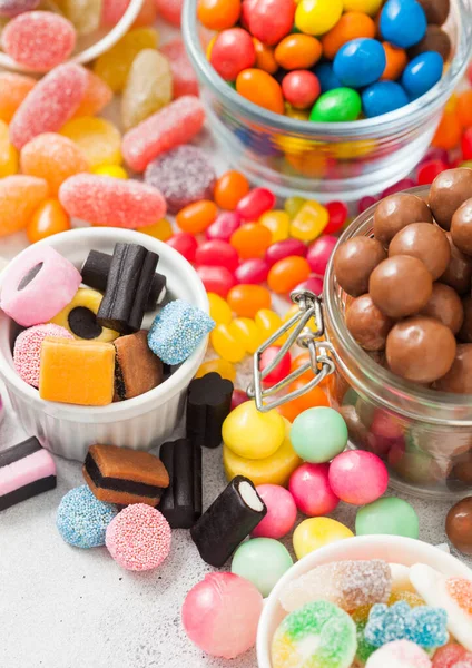 Sütlü Çikolatalı Şekerler Kavanozda Çeşitli Jöleli Diş Etleri Beyaz Masada — Stok fotoğraf