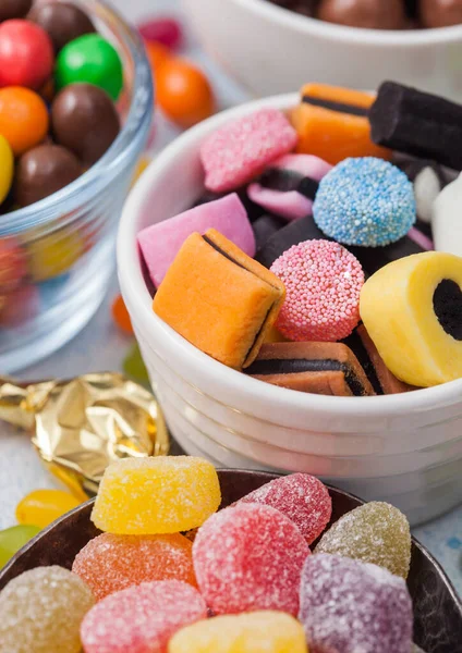 Meyan kökü şekerlemeleri, beyaz seramik tabağa karıştırılmış şekerlemeler ve çikolatalı şekerler..