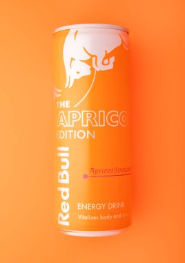 LONDON, UK - 27 AĞUSTOS 2025: Kayısı ve çilekli Red Bull enerji içeceği turuncu arka planda.