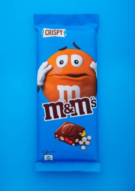 LONDON, İngiltere - 10 HAZİRAN 2025: Büyük mavi M ve M 'nin gevrek sütlü çikolatası mavi sırt damlasında. MM' nin çikolatası..