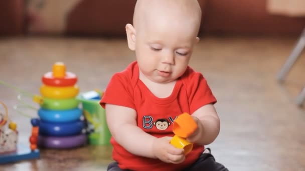 Bedårande liten pojke leker med liten leksak, leende. — Stockvideo