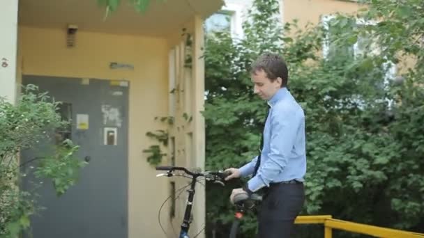Üzletember, a kerékpár-érint smartphone-val — Stock videók