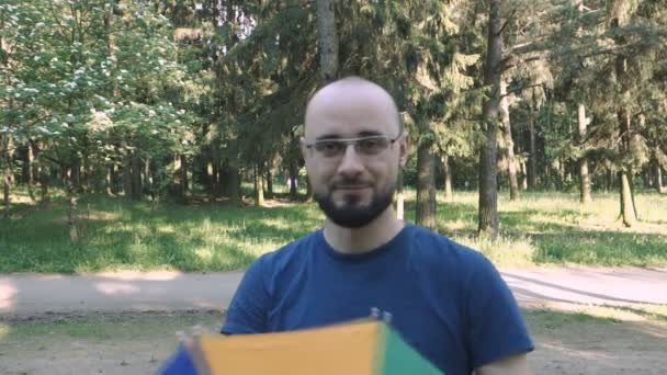 Retrato de homem feliz com chapéu de arco-íris guarda-chuva na cabeça — Vídeo de Stock